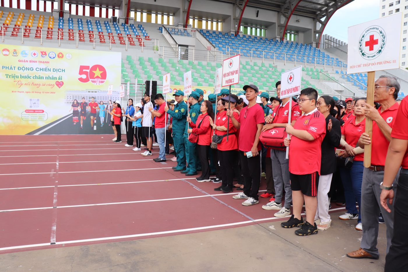 Các đoàn Hội Chữ thập đỏ phường cầm bảng tên đơn vị xếp hàng trên sân vận động tại lễ phát động chiến dịch