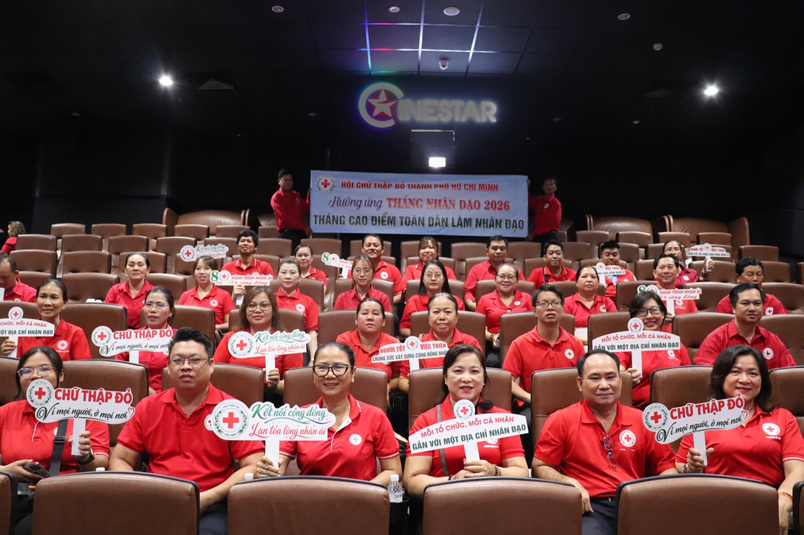 Cán bộ và tình nguyện viên Chữ thập đỏ cầm bảng khẩu hiệu tại lễ hưởng ứng Tháng Nhân đạo 2026